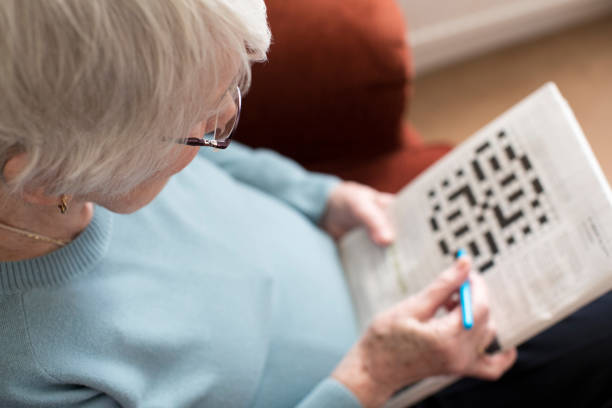 認知症予防の為にクロスワードパズルを行う高齢者